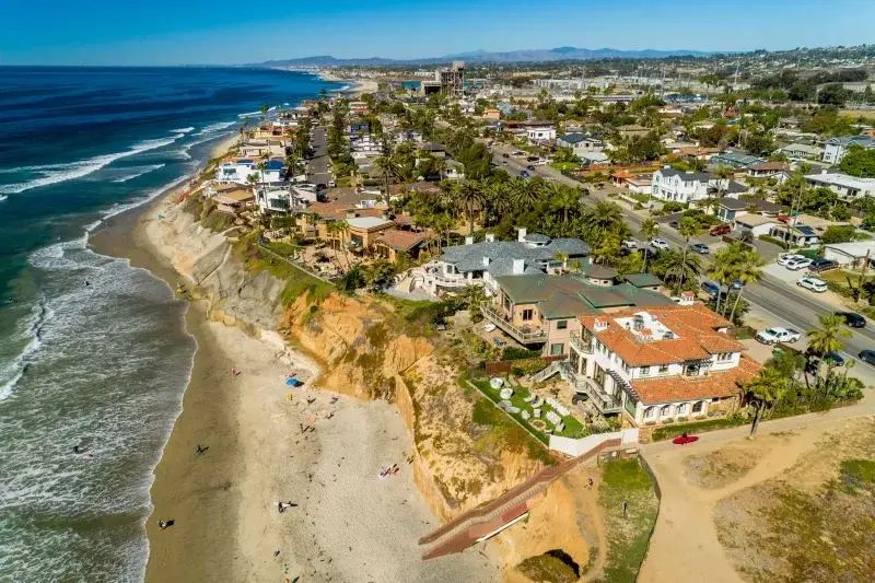 Luxury coastal homes in Carlsbad, CA with palm trees and ocean views, representing the upscale real estate market in North County San Diego.