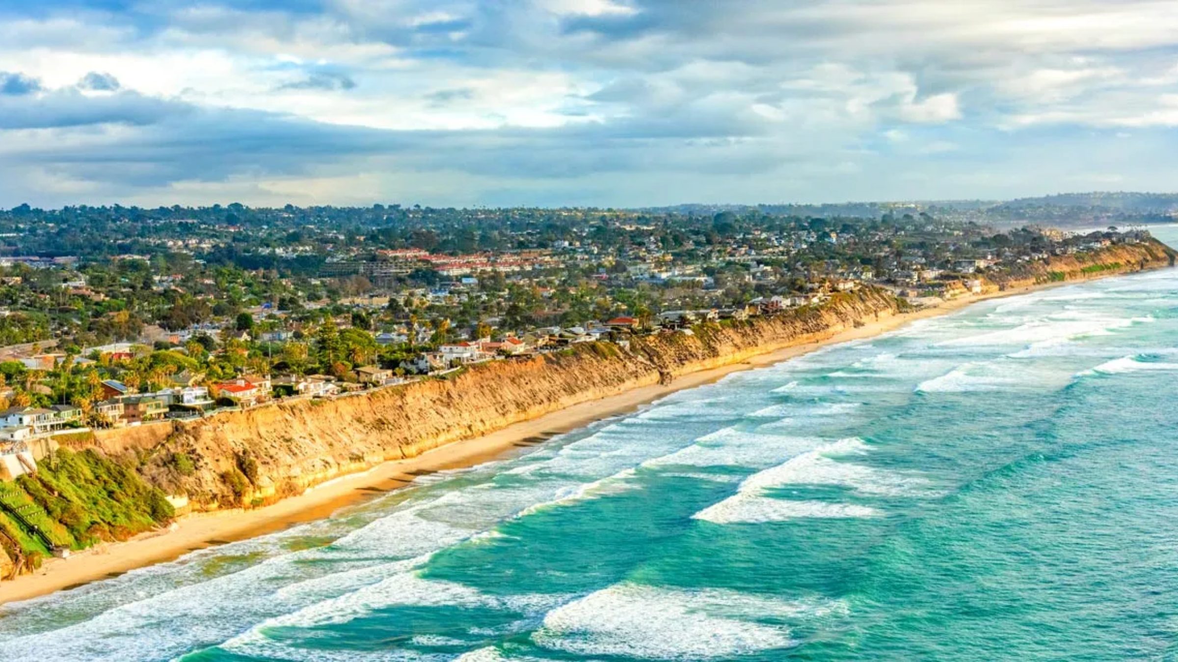 Scenic coastline in North County San Diego with blue ocean, sandy beaches, and sunny skies